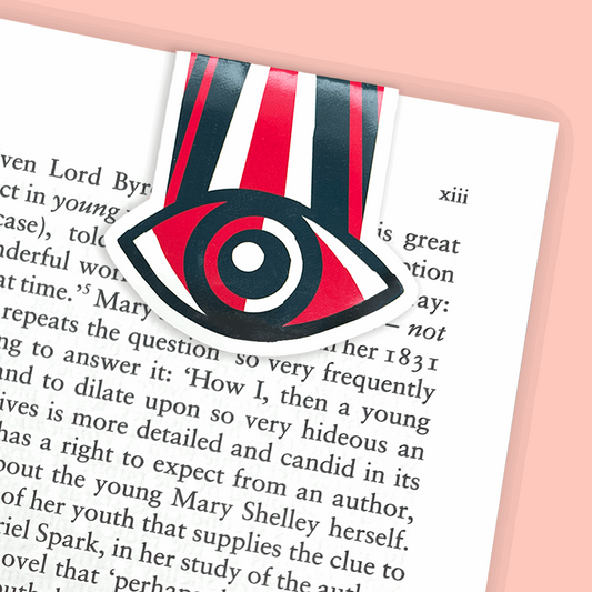 A magnetic bookmark featuring an eye in black, red and white inspired by 1984