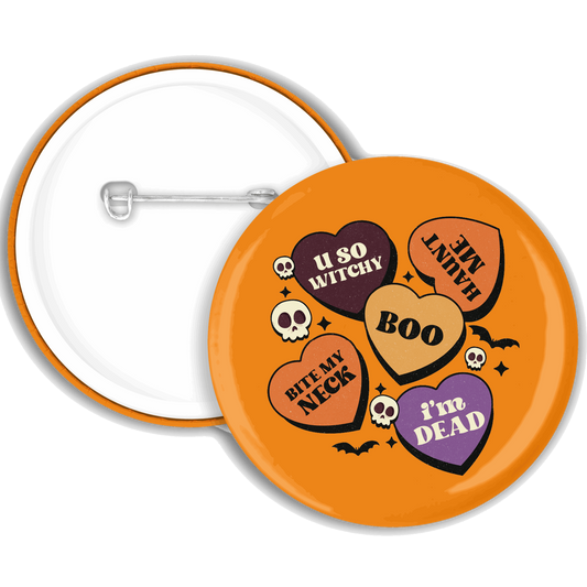 An orange badge with multiple spooky hearts with sayings on
