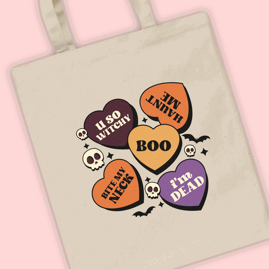 A natural tote bag with multiple Halloween spooky hearts with sayings on
