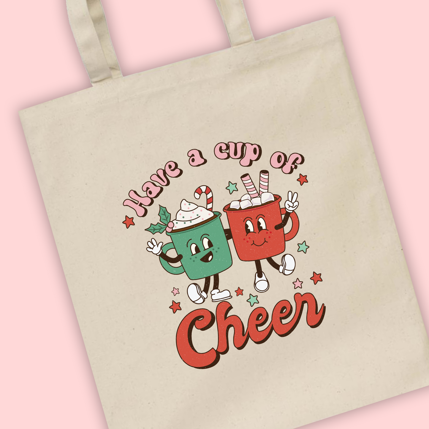 A natural tote bag of Have A Cup Of Cheer written with an illustration of two Christmas hot chocolates