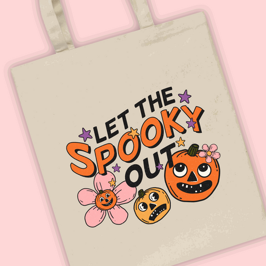 A natural tote bag with ‘let the spooky out’ written with a pumpkin illustration