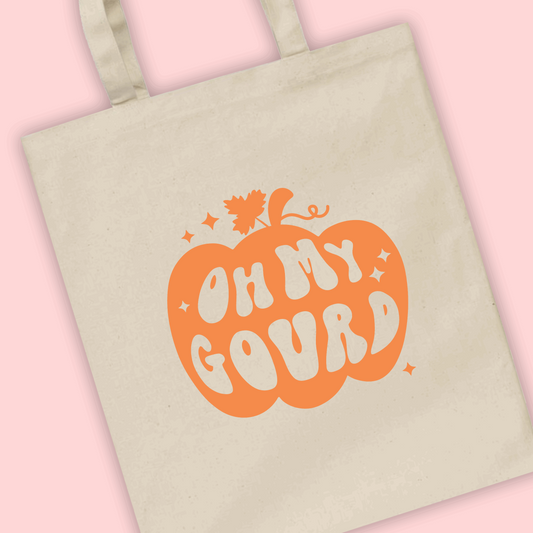 A natural tote bag with the phrase .oh my gourd’ written in a pumpkin