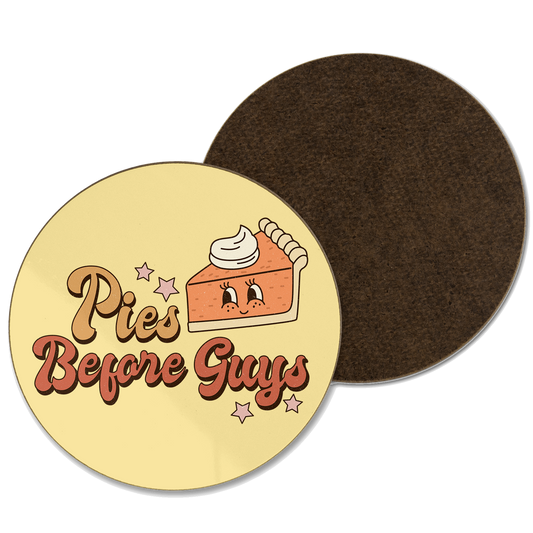 A yellow coaster with ‘pies before guys’ written with an illustration of a pumpkin pie