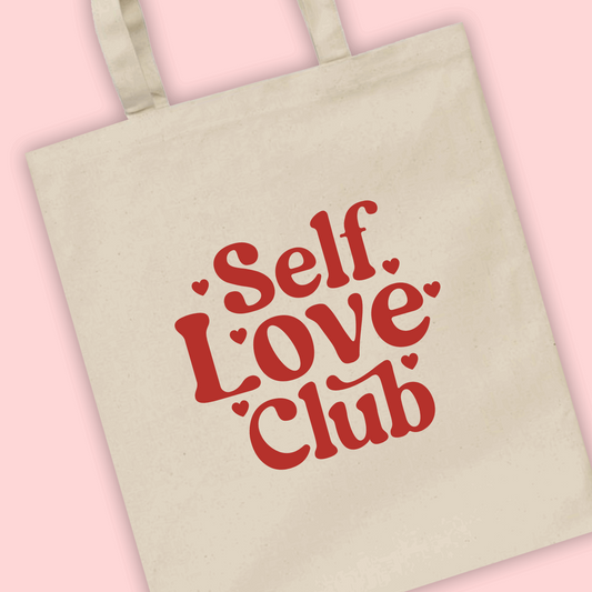 A natural tote bag with ‘self love club’ written in red