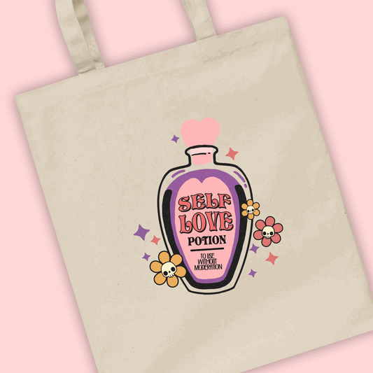 A natural tote bag with a pink and purple potion bottle illustration with Self Love Potion written