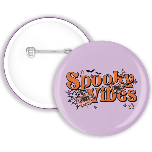 A purple badge with spooky vibes written and cobweb illustrations 