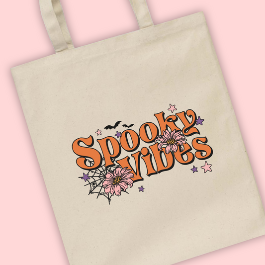 A natural tote bag with ‘spooky vibes’ written with cobweb Illustrations