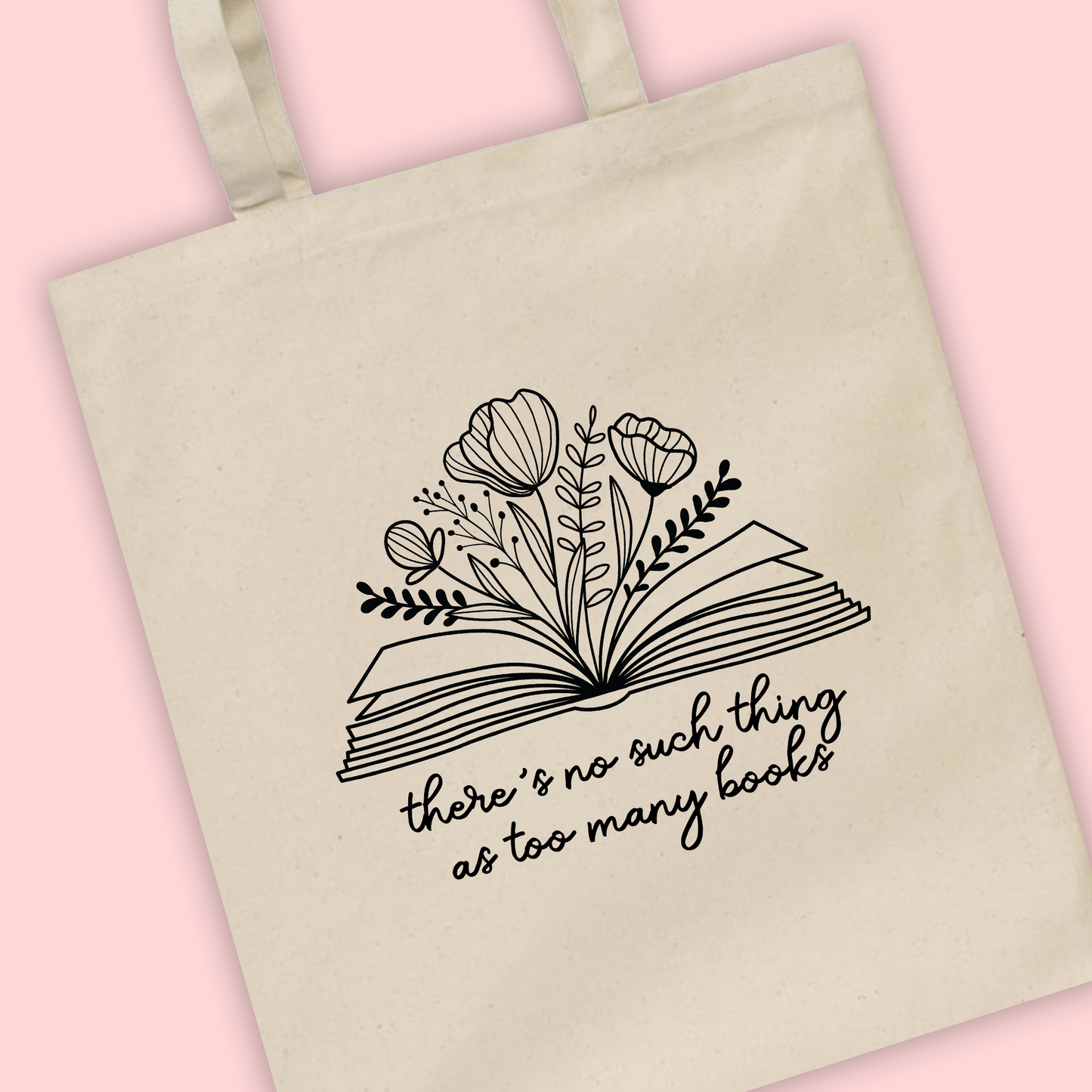 A natural tote bag with ‘There’s never too many books’ written with a book illustration with flowers