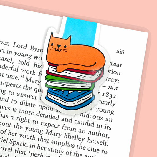 A magnetic bookmark with an illustration of a cat sat on books